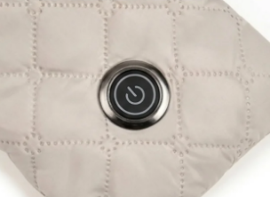 Close-up of the Thermora heat control button on quilted beige fabric
